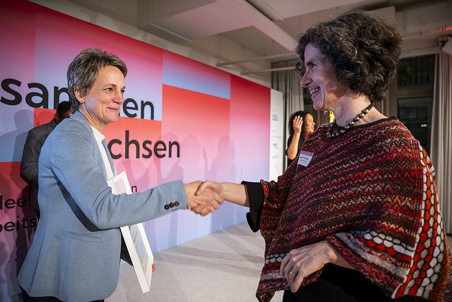 Dr. Elisabetta Terrasi-Haufe (rechts) nimmt am 3. Dezember 2025 in Berlin die Auszeichnung für das Projekt mona lea entgegen.