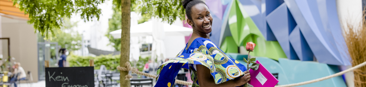 Teilnehmerin des Visumskurses mit Rose in der Hand