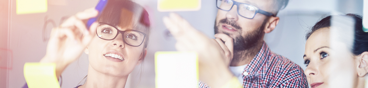 Foto Personen beraten sich vor einem Memo-Board