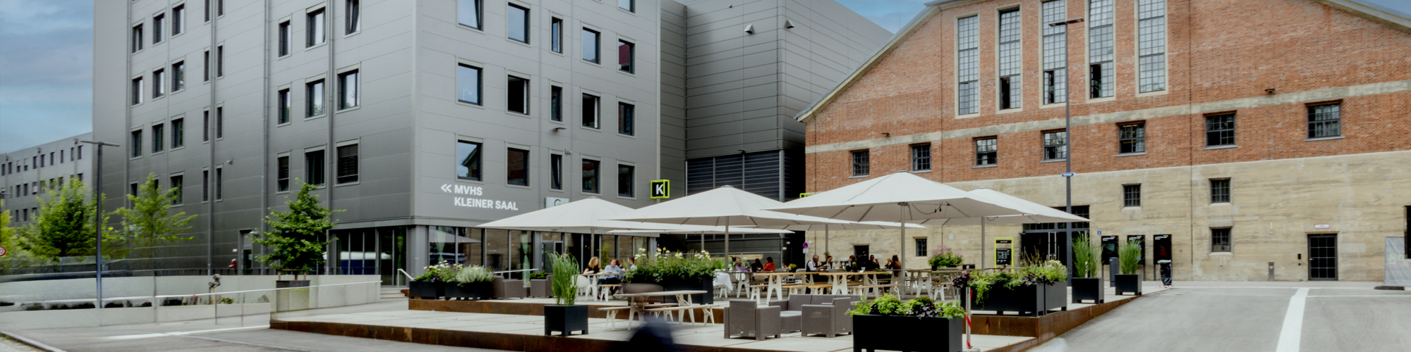Foto Vorplatz des Gasteig HP8 mit Terrasse und Sonnenschirmen 